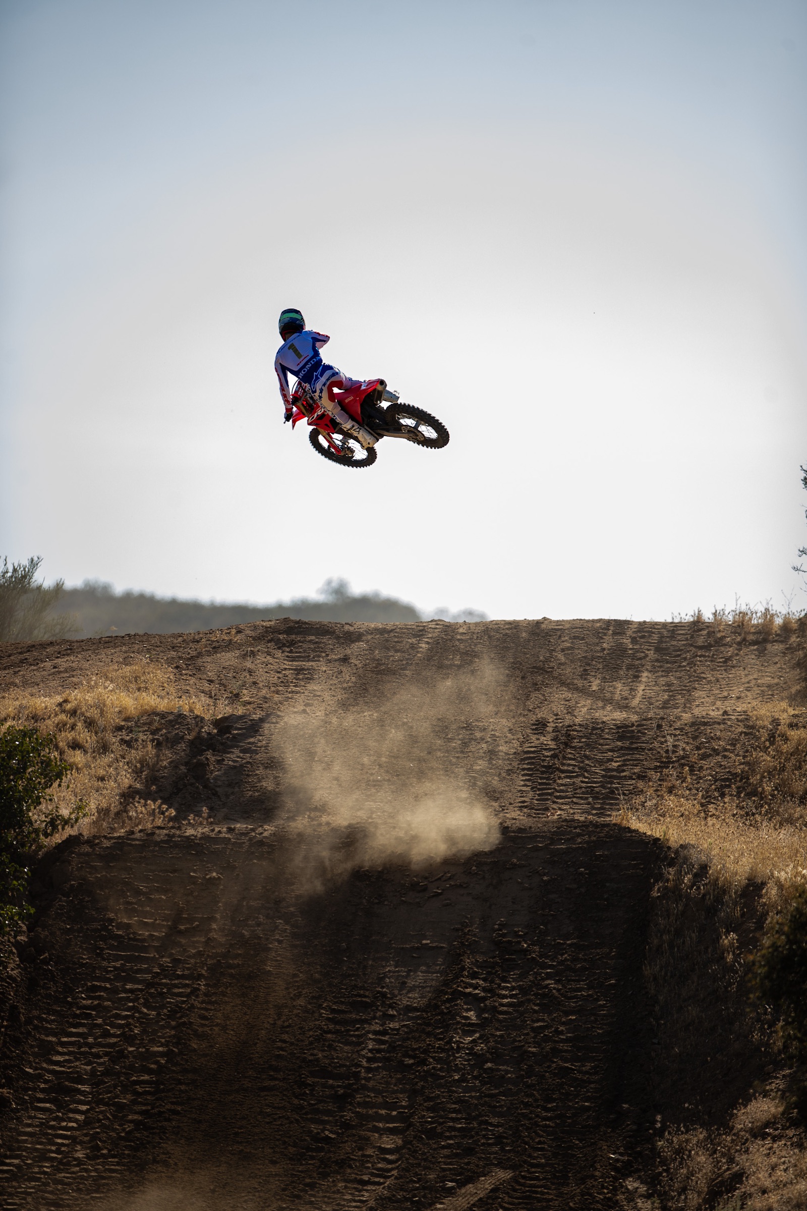 Honda CRF250R rider jumping over a motocross track