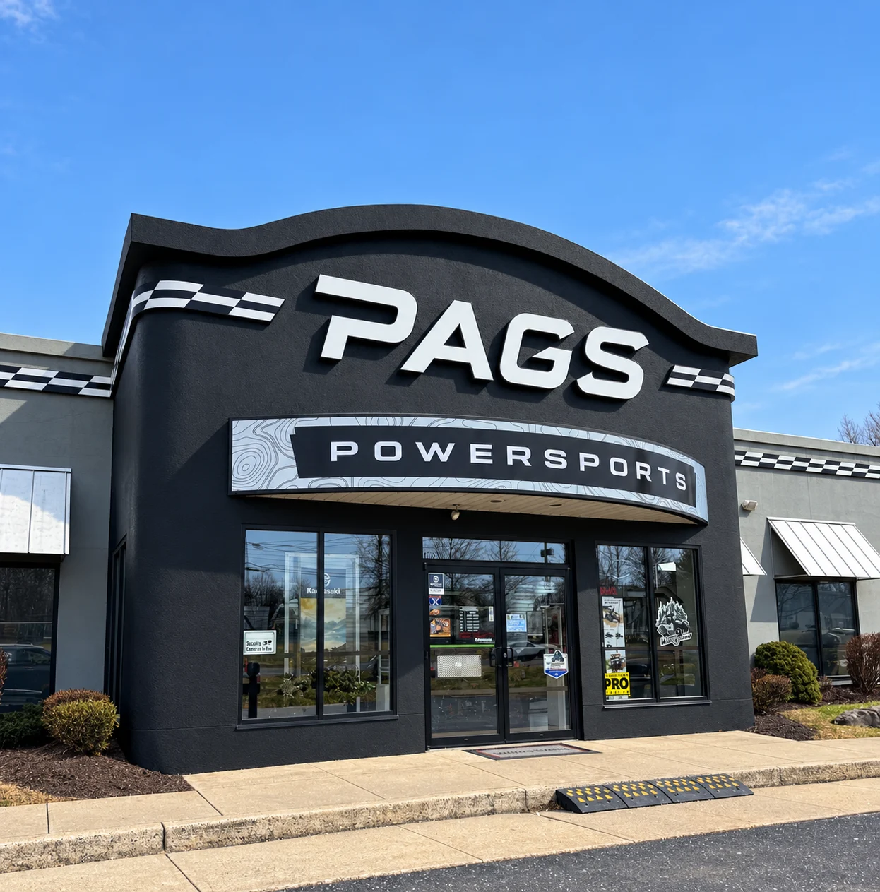 Pags Powersports entrance and signage on a blue-sky day